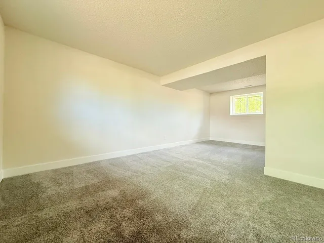 a view of empty room with wooden floor and windows
