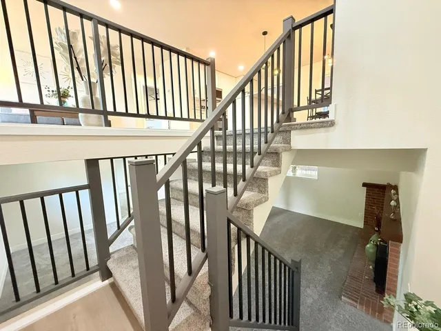 a view of staircase with railing and white walls