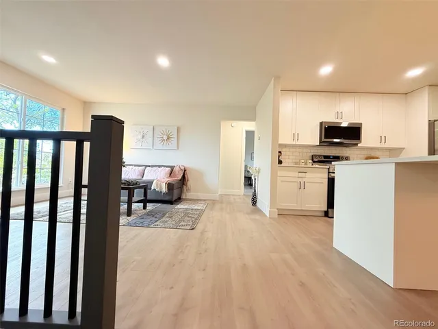a kitchen with furniture a refrigerator and a stove top oven