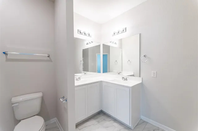 a bathroom with a sink mirror vanity and toilet