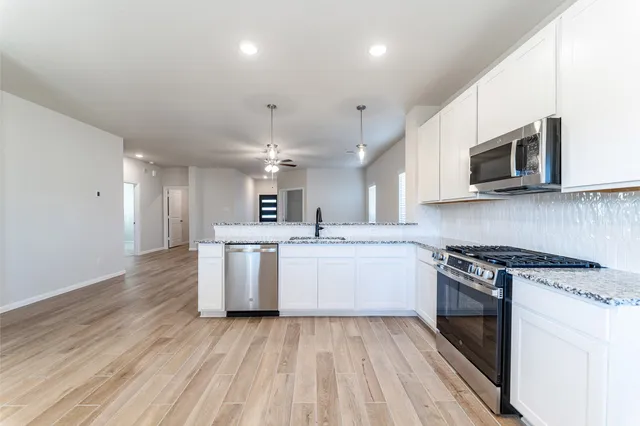 a kitchen with a white stove top oven and white cabinets