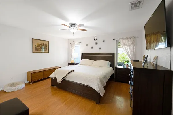 a bedroom with a bed a flat screen tv and dresser