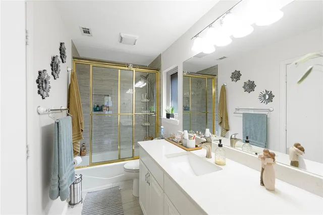a bathroom with a double vanity sink toilet and shower