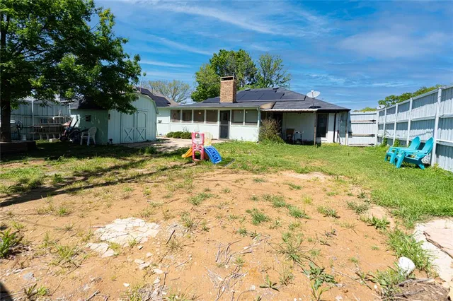 a view of a house with backyard and sitting area
