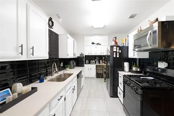 a kitchen with granite countertop a sink a stove and refrigerator