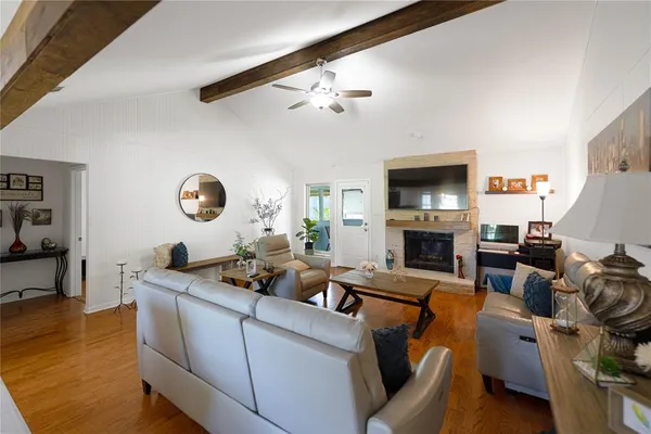 a living room with furniture a fireplace and a flat screen tv