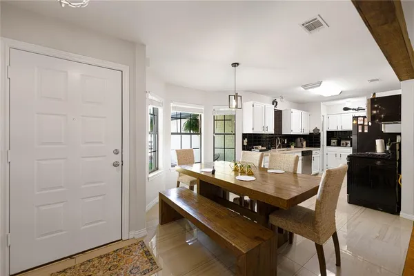a dining hall with stainless steel appliances kitchen island granite countertop a dining table and chairs with wooden floor