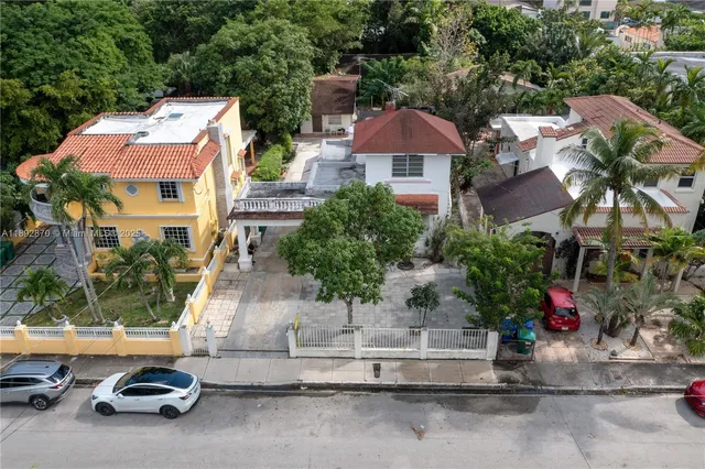 a couple of cars parked in front of a house