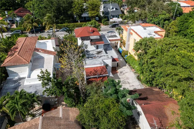 an aerial view of a houses with greenery space and a street view