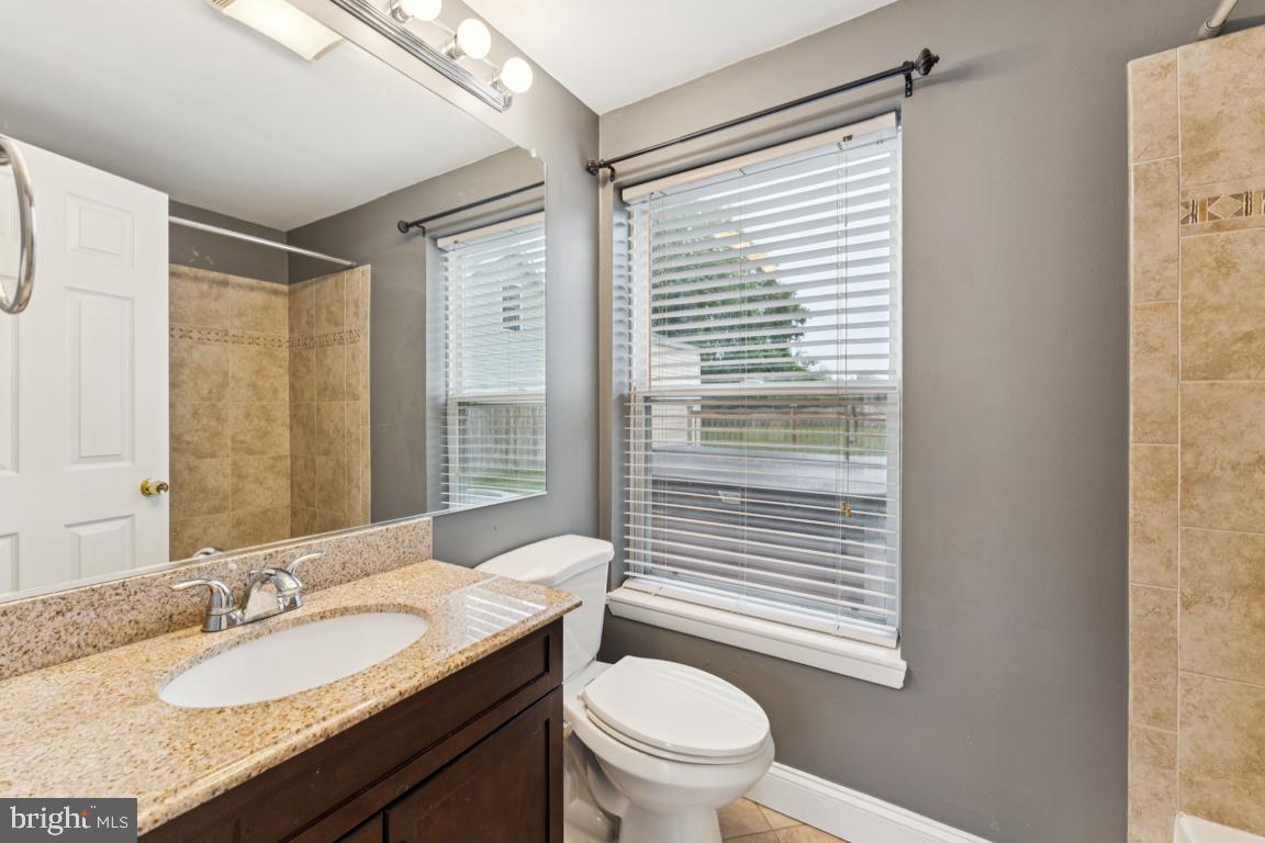 5 Brookfield Road Pasadena, MD 21122 - Photo 15 of 34 a bathroom with a granite countertop sink toilet a mirror and shower