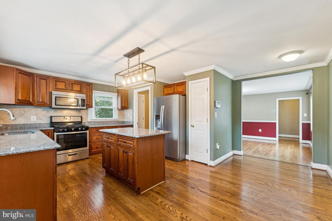 5 Brookfield Road Pasadena, MD 21122 - Photo 6 of 34 a kitchen with stainless steel appliances granite countertop a stove refrigerator and cabinets