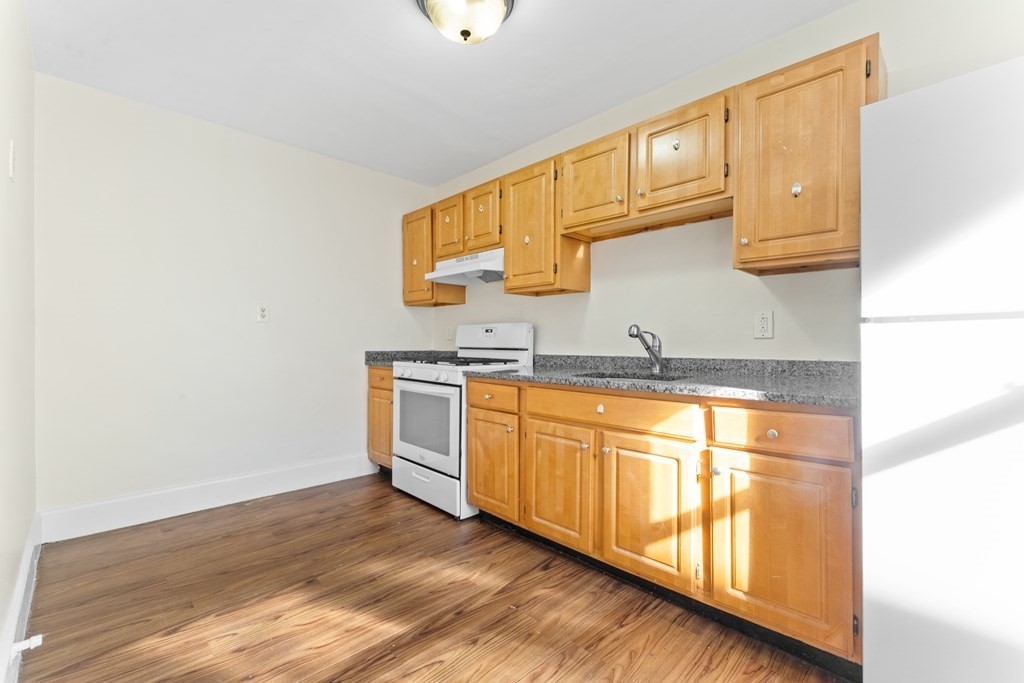 11 Victory Road, Unit 32 Boston, MA 02122 - Photo 2 of 16 a kitchen with stainless steel appliances granite countertop a sink and cabinets