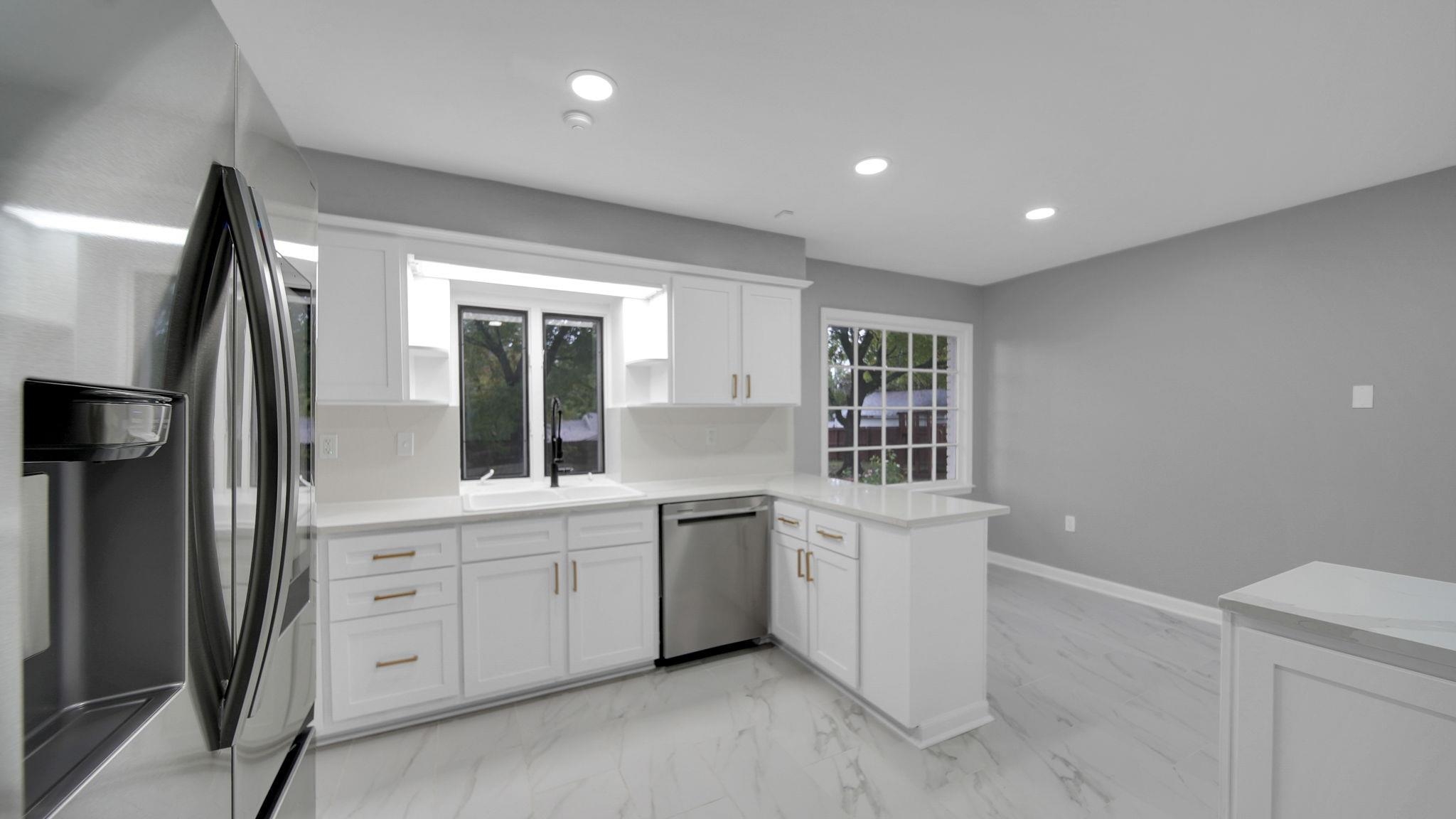 5256 Collingwood Road Memphis, TN 38117 - Photo 15 of 40 Kitchen featuring stainless steel appliances, a peninsula, white cabinets, light marble finish floors, and recessed lighting