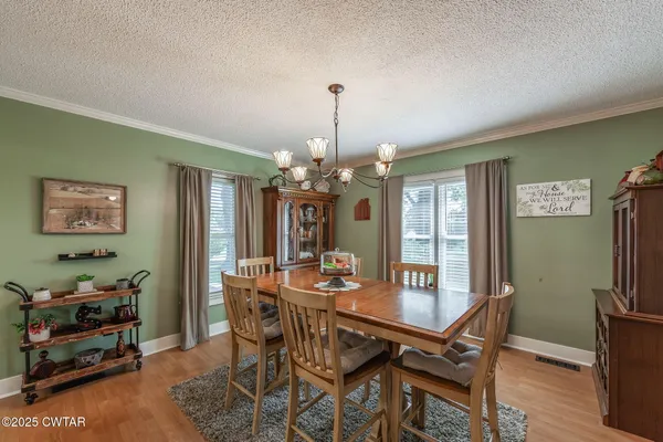 a dining room with furniture a chandelier and wooden floor