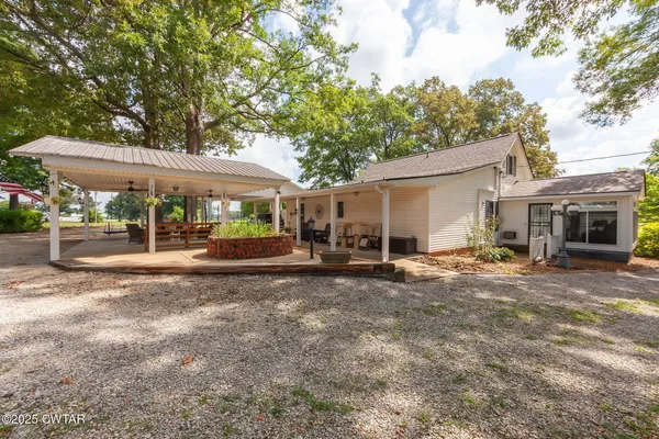 a view of a house with backyard and sitting area