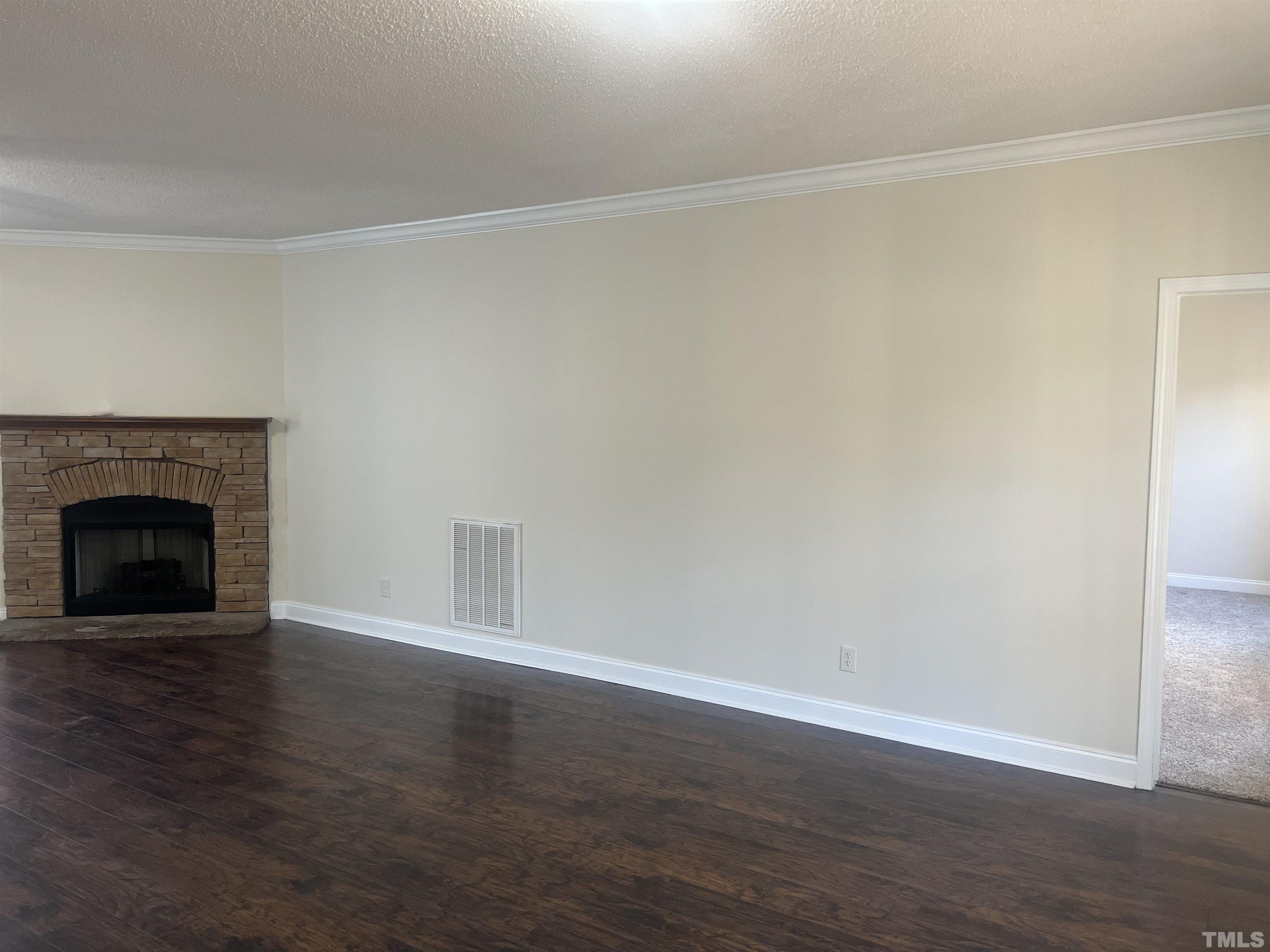 1219 Ridge Road Benson, NC 27504 - Photo 18 of 57 a view of an empty room with wooden floor fireplace and a window