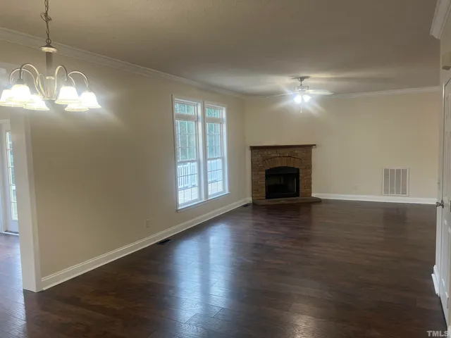 a view of a room with wooden floor and chandelier