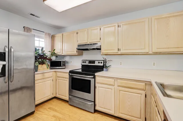 a kitchen with white cabinets and stainless steel appliances