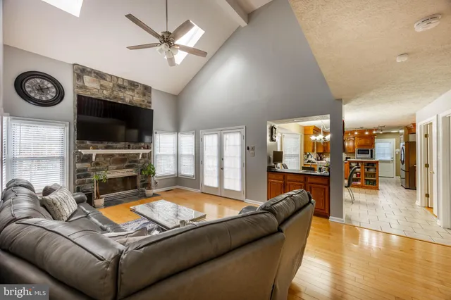 a living room with furniture and a flat screen tv with kitchen view