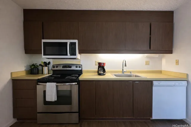 a kitchen with a sink and steel appliances