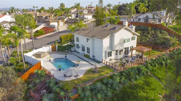 an aerial view of a house with a yard and trees