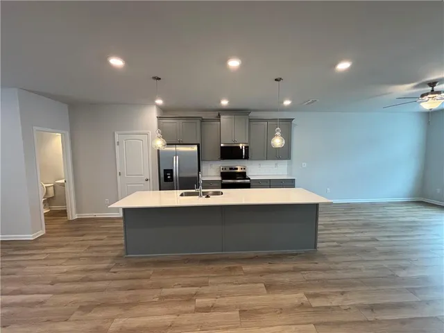 a view of kitchen with kitchen island microwave and wooden floor