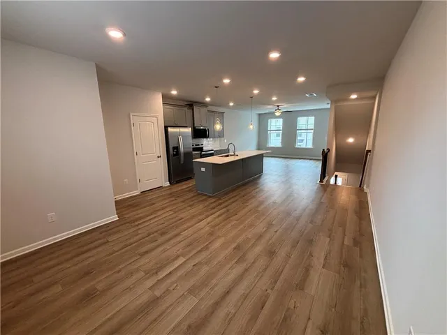 a view of a kitchen with kitchen island wooden floor center island and stainless steel appliances