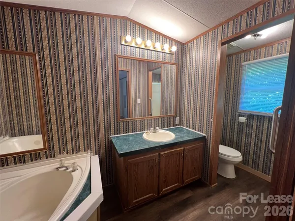 a bathroom with a sink a toilet a mirror and shower