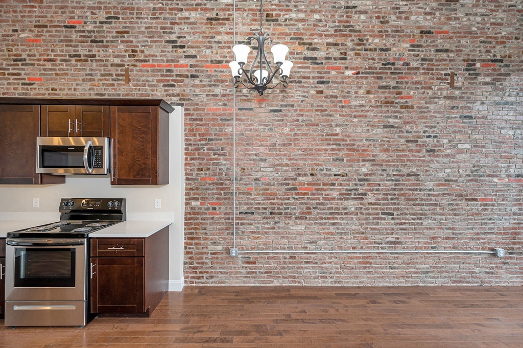231 Central Street, Unit 203 Lowell, MA 01852 - Photo 11 of 15 a kitchen with stainless steel appliances a stove and a sink