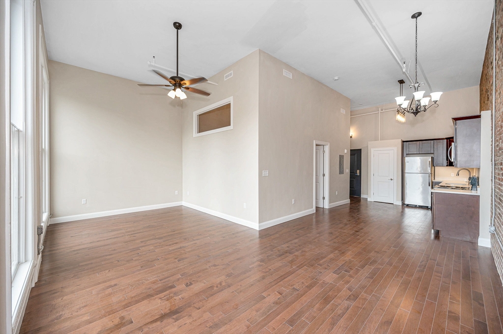 231 Central Street, Unit 203 Lowell, MA 01852 - Photo 12 of 15 a view of a livingroom with a ceiling fan wooden floor and a ceiling fan
