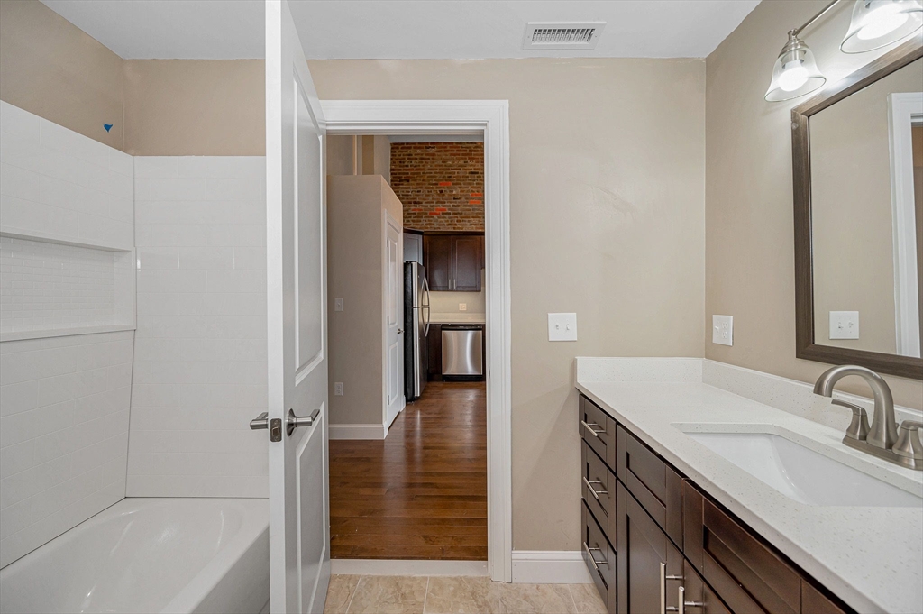 231 Central Street, Unit 203 Lowell, MA 01852 - Photo 4 of 15 a bathroom with a sink and a mirror