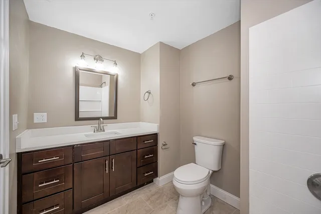 a bathroom with a toilet a sink and mirror