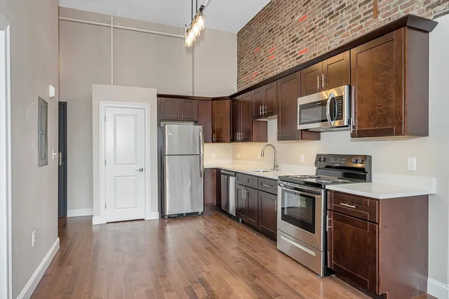 a kitchen with stainless steel appliances granite countertop a refrigerator a stove a sink dishwasher and a microwave oven with cabinets