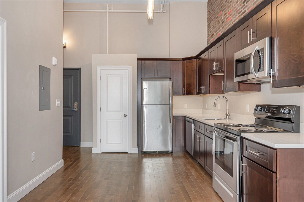 231 Central Street, Unit 203 Lowell, MA 01852 - Photo 9 of 15 a kitchen with stainless steel appliances granite countertop a refrigerator a stove top oven a sink and dishwasher