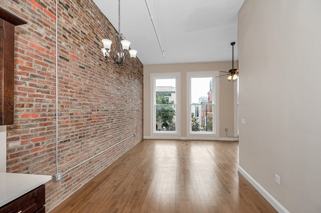 231 Central Street, Unit 203 Lowell, MA 01852 - Photo 10 of 15 a view of a room with wooden floor and a large window