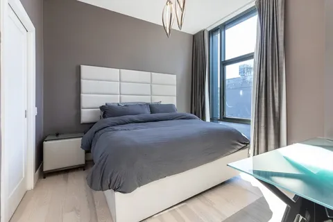 a bedroom with a bed and a flat tv screen on dresser