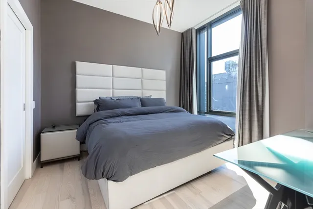 a bedroom with a bed and a flat tv screen on dresser