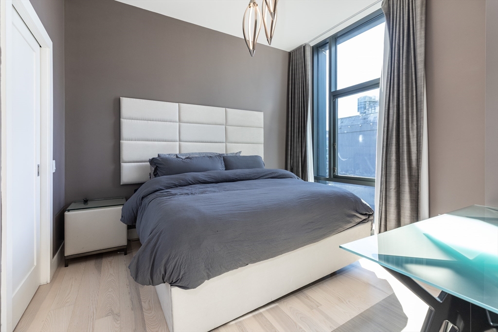 32 Traveler Street, Unit PH8 Boston, MA 02118 - Photo 12 of 38 a bed sitting in a bedroom next to a window