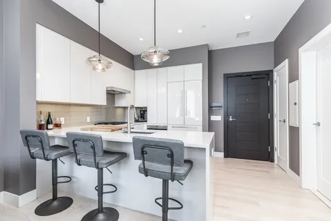 a kitchen with stainless steel appliances kitchen island granite countertop a stove a sink and a refrigerator