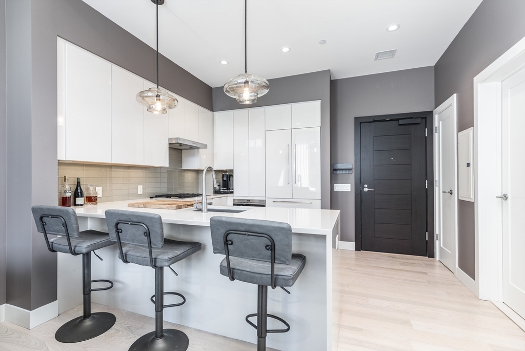 32 Traveler Street, Unit PH8 Boston, MA 02118 - Photo 6 of 38 a kitchen with stainless steel appliances kitchen island granite countertop a stove a sink and a refrigerator