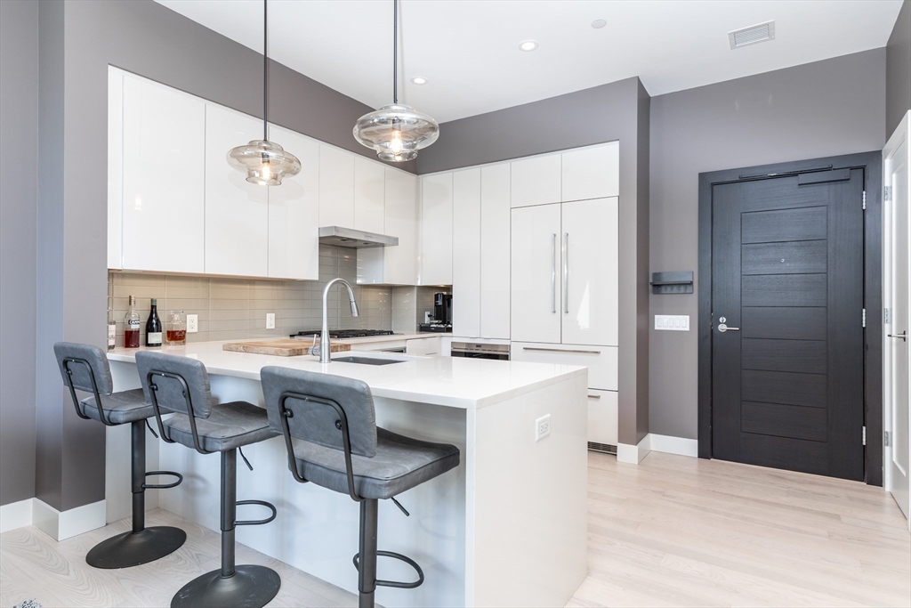 32 Traveler Street, Unit PH8 Boston, MA 02118 - Photo 7 of 38 a kitchen with stainless steel appliances kitchen island a chandelier