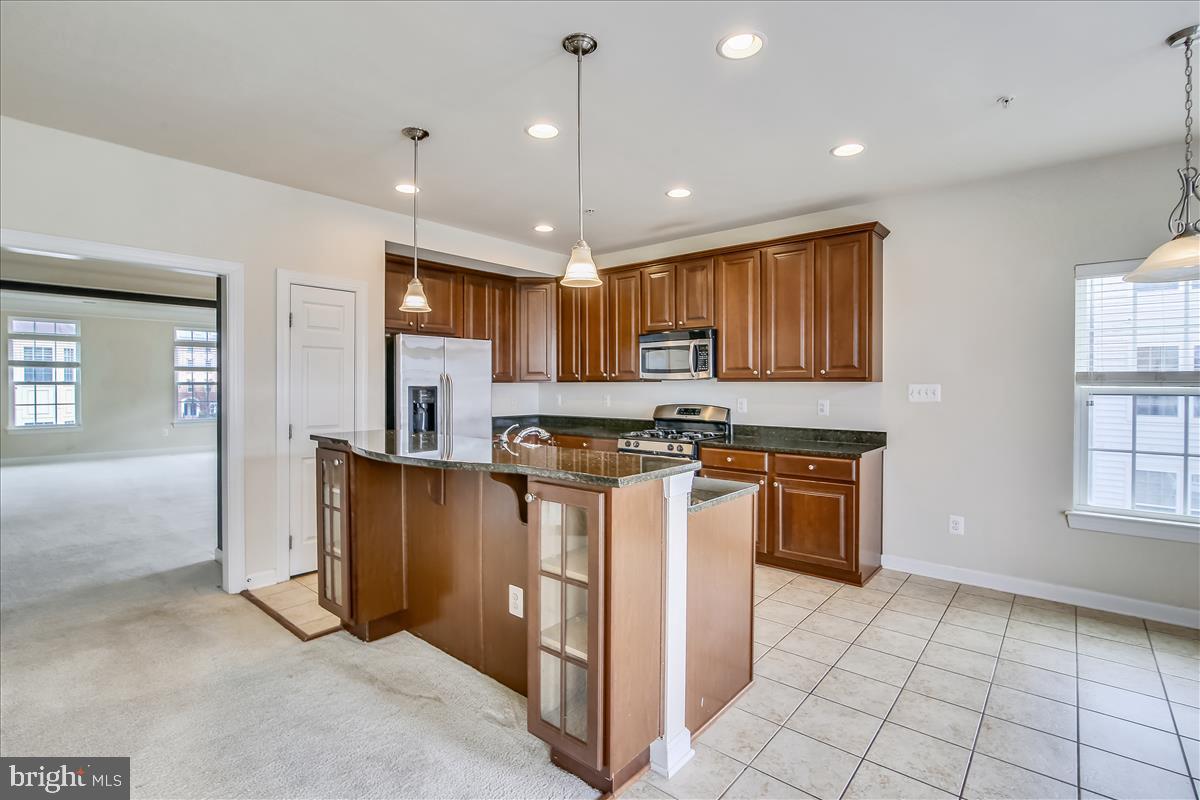 3602 Spring Hollow Lane Frederick, MD 21704 - Photo 9 of 25 a kitchen with stainless steel appliances granite countertop a refrigerator stove top oven and sink
