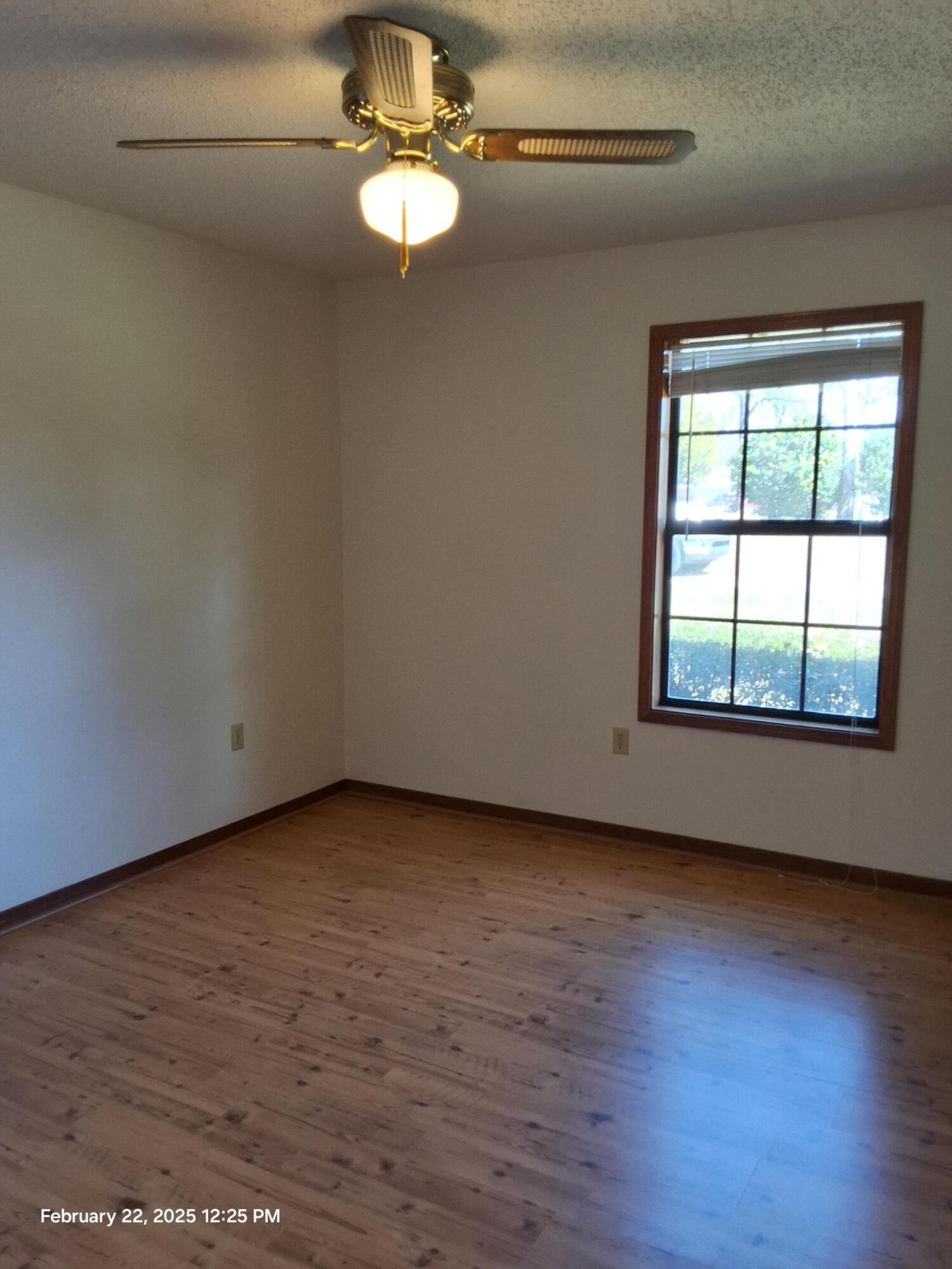 5652 Old Bethel Road Crestview, FL 32536 - Photo 11 of 23 an empty room with wooden floor chandelier fan and windows