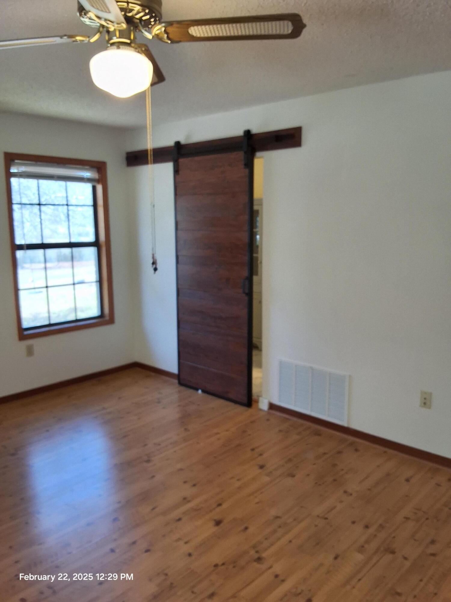 5652 Old Bethel Road Crestview, FL 32536 - Photo 20 of 23 an empty room with wooden floor fan and windows