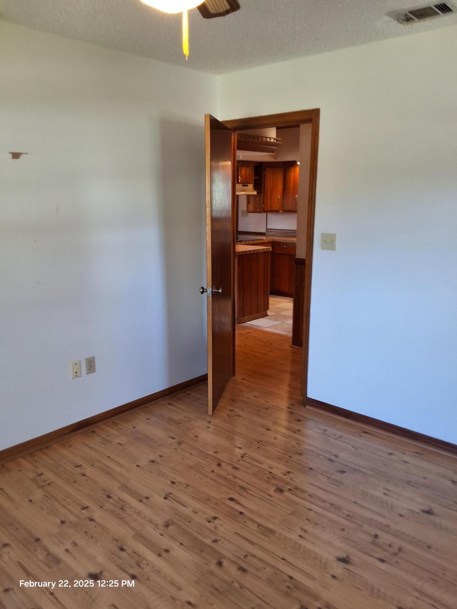 5652 Old Bethel Road Crestview, FL 32536 - Photo 10 of 23 a view of a hallway with wooden floor and a kitchen