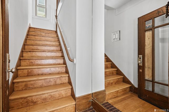 a view of a room with wooden floor and chandelier