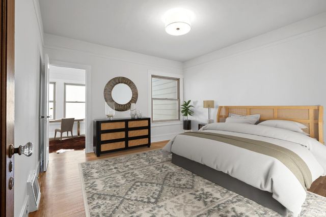 a view of a hallway with wooden floor and a cabinet