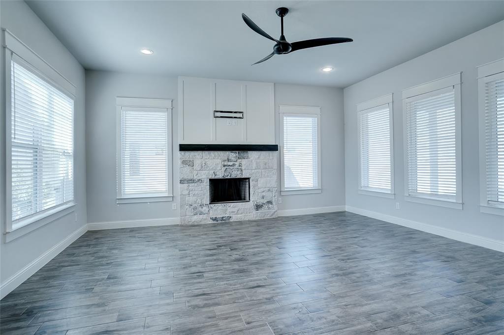 124 William Lane Godley, TX 76044 - Photo 12 of 32 an empty room with wooden floor a fireplace and windows