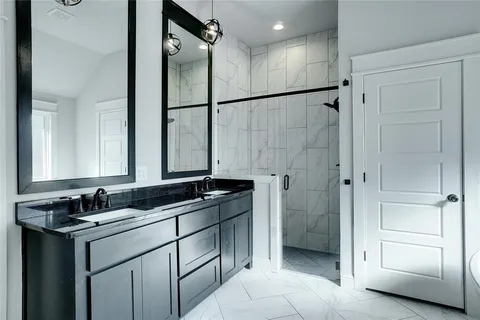 a bathroom with a double sink shower and mirror