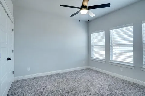 an empty room with a window and a fan